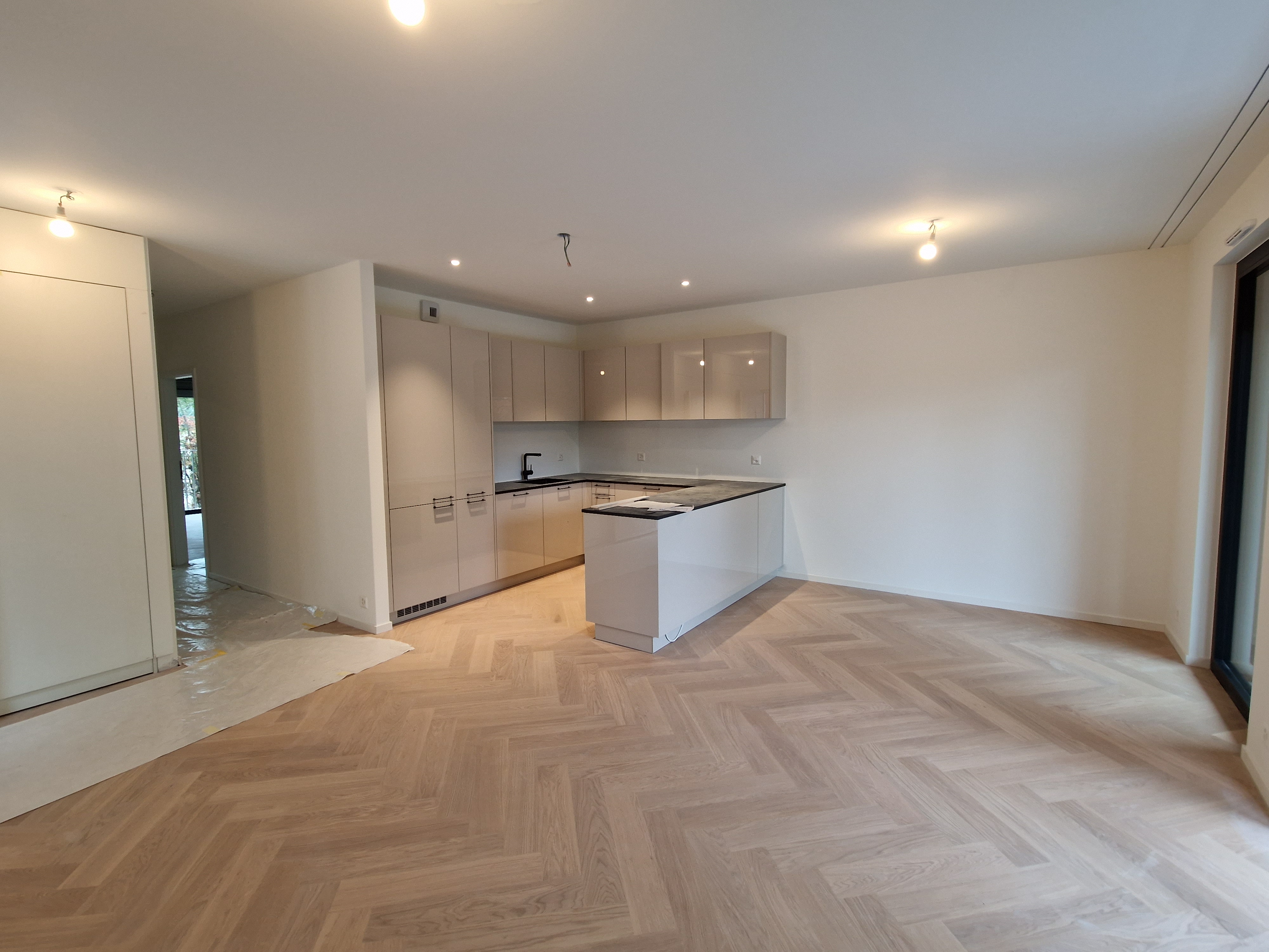 Cuisine ouverte avec îlot et parquet en chevron